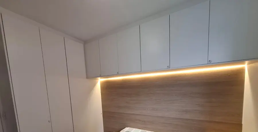 Quarto de casal com painel amadeirado e LED