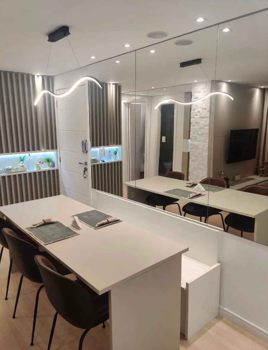 Sala de jantar planejada com parede espelhada